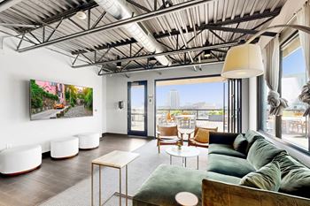 A living room with a green couch and a painting on the wall.